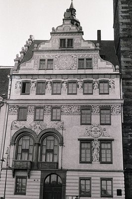Elaborate, stucco-decorated facade of a Renaissance-era building. Features multiple windows, a balcony, and intricate sculptu...