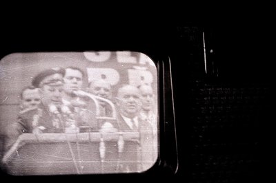 Vintage monochrome slide depicting a group of formally-dressed men, likely on a ship's deck. Visible are hats, jackets and a ...