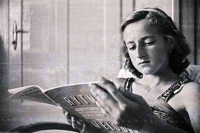 Young woman absorbed in sheet music, likely vocal practice. Simple beaded dress & headband highlight a poised, introspective ...