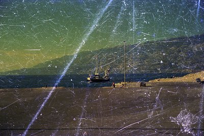 Seascape featuring a working dock, likely a port or industrial area. Visible are cranes, a small vessel, and what appears to ...