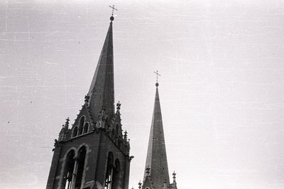 Dramatic, high-angle view of two Gothic spires reaching skyward. Detailed tracery and pointed arches are visible. Likely a ca...
