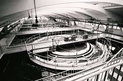 Intricate view of a large, multi-tiered pool system with a spiral central feature and raised walkways. Likely a research or a...