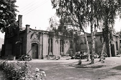 Grandiose brick building, likely a former industrial or municipal structure, features arched entrance & decorative brickwork....