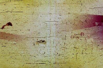 A heavily distressed photo featuring a blurry landscape with muted purple and gray tones. Significant damage and discoloratio...