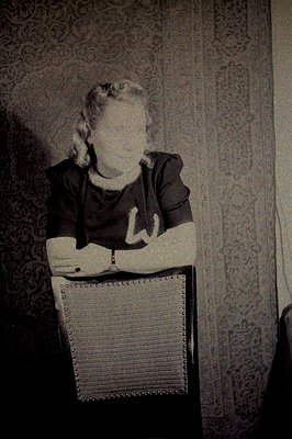 A seated person with long hair and a visible ring wears a dark t-shirt bearing a large "W" graphic. A vintage aesthetic, like...