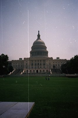 A wide, slightly grainy, view of the U.S. Capitol Building in Washington D.C. Shows the extensive front lawn and monumental s...