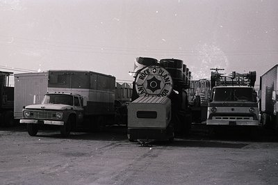 Black-and-white photo of vintage mobile printing press trucks, likely from the **1960s-1970s**. Central unit features "The Ra...