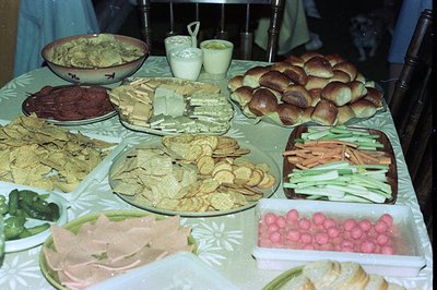 Vintage spread featuring homemade baked goods, pickled vegetables, and fresh produce on a floral-patterned tablecloth. Round ...