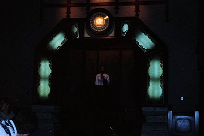 Vintage neon-lit signage featuring a central circular clock with illuminated hour markers and hands, flanked by two vertical ...