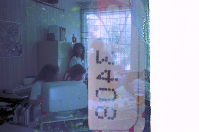 Vintage kitchen interior with blurred, reflective glass door displaying "Lavazza" coffee logo. White fridge, shelves with bot...