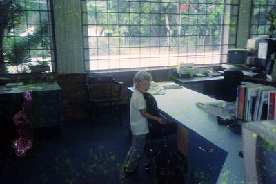 Vintage classroom scene with child standing by desk, surrounded by chalkboard splatter. Mid-20th century educational setting,...