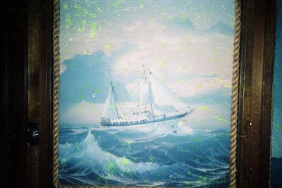 Vintage maritime painting depicting a three-masted sailing ship navigating rough seas. Stormy waves and misty horizon suggest...