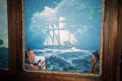 Vintage maritime mural depicting a three-masted sailing ship on turbulent seas, framed by aged wooden borders. Below the ship...
