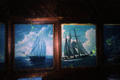 Vintage maritime paintings of two sailing ships on stormy seas, framed in dark wood with aged patina. Glow-in-the-dark paint ...