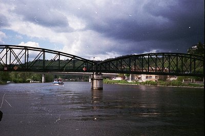 Mid-20th century steel truss bridge spanning a river, likely for rail or mixed traffic. Industrial-era design with riveted me...