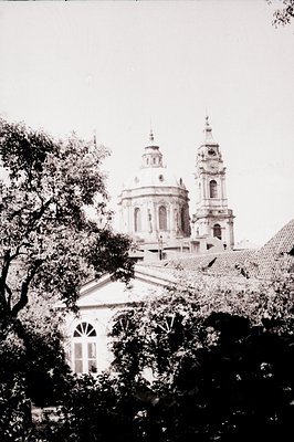 Baroque-style church with twin domed towers framed by foliage; vintage black-and-white print suggests mid-20th century. Archi...