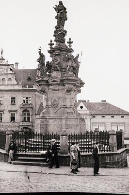 Baroque-style fountain with ornate stonework, featuring a central statue of a robed figure atop a multi-tiered pedestal adorn...