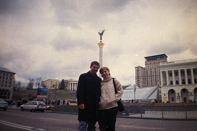 A couple stands before Ukraine's Independence Square (Maidan Nezalezhnosti) featuring the iconic Pillar of Liberty monument. ...