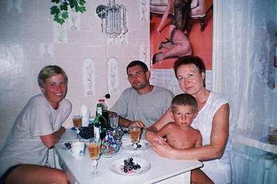 Family portrait, possibly on vacation, circa 1980s. Features a man, woman, young boy, and a fourth person cropped out. Drinks...