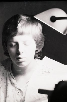 Close-up portrait of a young person with short, textured hair, appearing contemplative. The subject wears a patterned blouse ...