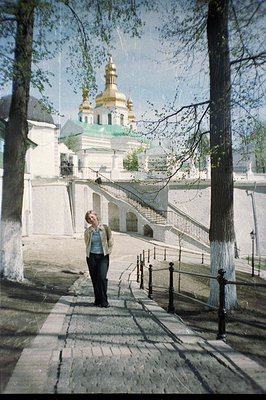 A young woman walks on a stone path towards a grand staircase leading up to the Saint Sophia Cathedral in Kyiv, Ukraine. The ...