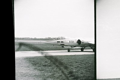 Black and white photo captures a Dassault Mirage III fighter jet taxiing on an airfield. Marked “R-759”, the aircraft exhibit...
