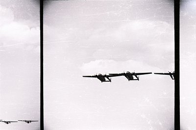 Four vintage, twin-engine aircraft fly in formation across a cloudy sky. Likely a military training exercise or transport mis...