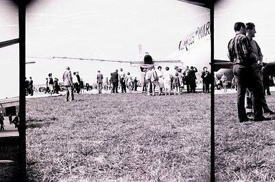 A crowd gathers around a large airplane on a grassy field. The aircraft, possibly a Douglas DC-8, bears the "Czechoslovak Air...
