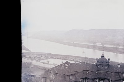 Elevated view overlooking a wide river & cityscape, featuring distinctive dome architecture and red-tiled roofs. The backgrou...