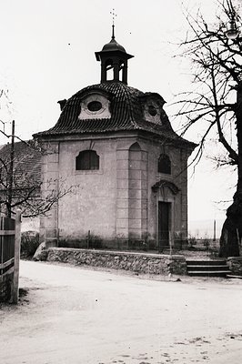 Ornate, small chapel with a domed roof & arched entrance, possibly Baroque style. Stone construction, surrounded by a low wal...