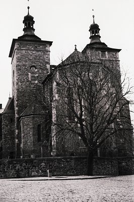Striking black and white view of a stone church with prominent bell tower and dome roofs. Detailed architectural elements sho...