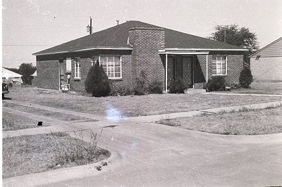 Classic mid-century modern ranch house with a low-pitched roof, brick facade, and neatly trimmed landscaping. Visible details...