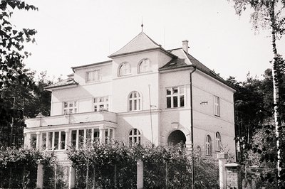 Elegant villa with a central turret and veranda, typical of early 20th-century architecture. Features arched entrance, multi-...
