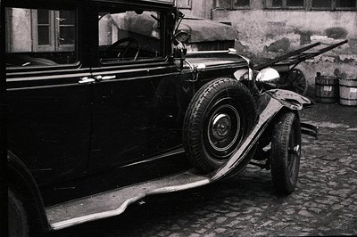Detailed view of a vintage automobile, likely a 1930s model, with a running board extending from the front fender. Mud and gr...