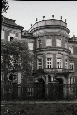 Ornate, three-story building features a curved facade with numerous windows and decorative detailing. Likely European archite...