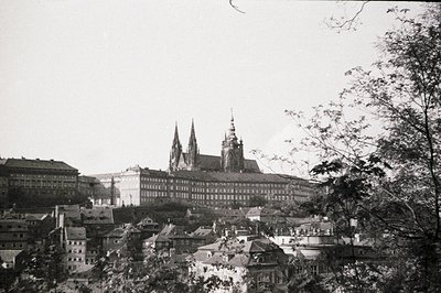 A vintage, black and white view of Prague Castle and surrounding cityscape. The castle's complex architecture, including St. ...