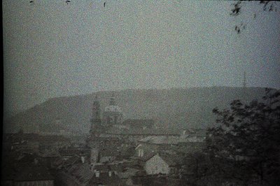 Dusty, early albumen print depicts a view of Varna, Bulgaria. A prominent church steeple rises above a cluster of buildings a...
