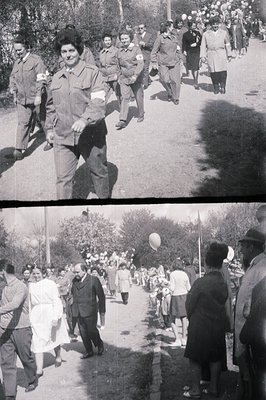 Group photograph depicting a procession of medical personnel, identifiable by red cross armbands, walking along a sloped, pav...