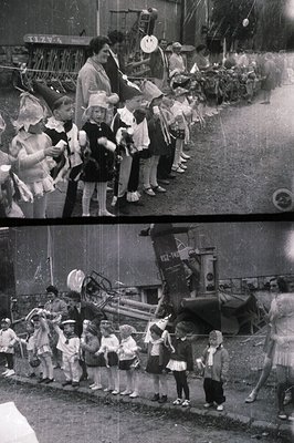 Group of children, many wearing matching hats, pose alongside a decorated tractor. Sign visible reads "TLZV." Appears to be a...