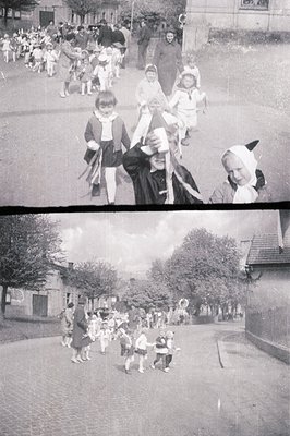 A group of children, many in period clothing & headwear, parade down a cobblestone street. A mix of formal and candid express...