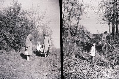 Four figures navigate a rural path, likely gathering materials. The group includes two adults in overcoats and a child in a w...