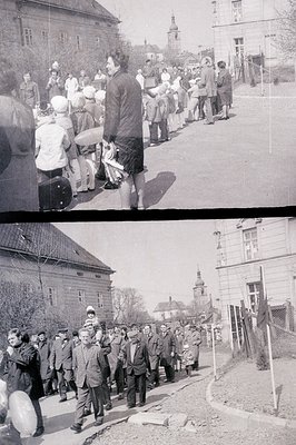 Here's a description of the image, following your detailed instructions: A crowd gathers on a street, watching people in form...