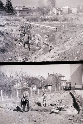 An excavation site shows workers constructing infrastructure – pipes and a trench dominate the foreground. Background feature...