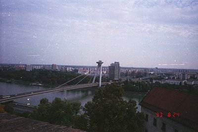 A panoramic view captures Belgrade, Serbia. The Sava River flows towards the viewer, crossed by a cable-stayed bridge. Modern...