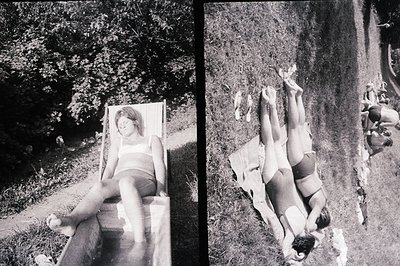 Here's a description of the photograph, formatted as requested: Relaxed figures lounge in a natural, overgrown setting. A wom...