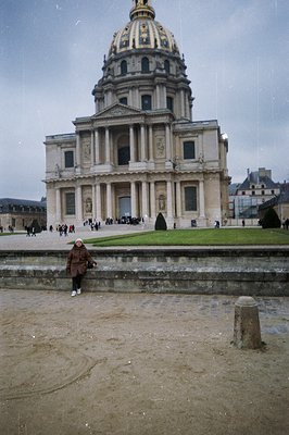 A person stands near the Invalides complex in Paris, France. The monumental building, featuring a gilded dome, is a prominent...
