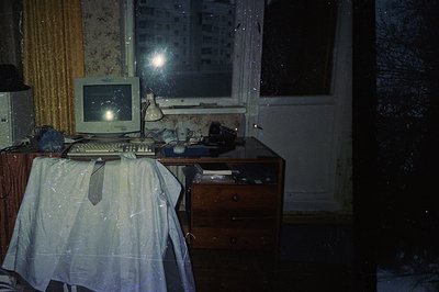 Dusty interior showing a vintage CRT computer setup on a draped dresser. A tan patterned wall & window reveal a snowy exterio...