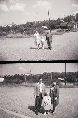 A family portrait, likely posed, features a man, woman, and young girl in front of a stone structure, possibly a church. Mid-...