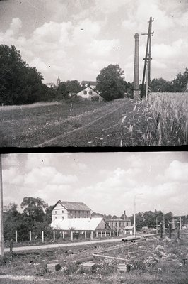 Rural scene showcasing a factory or industrial building with tall chimneys and surrounding farmland. Shows a railway line, wo...