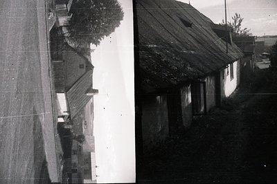 A side view of a traditional building with a steeply pitched, thatched roof. The exterior walls are rendered in a light-color...